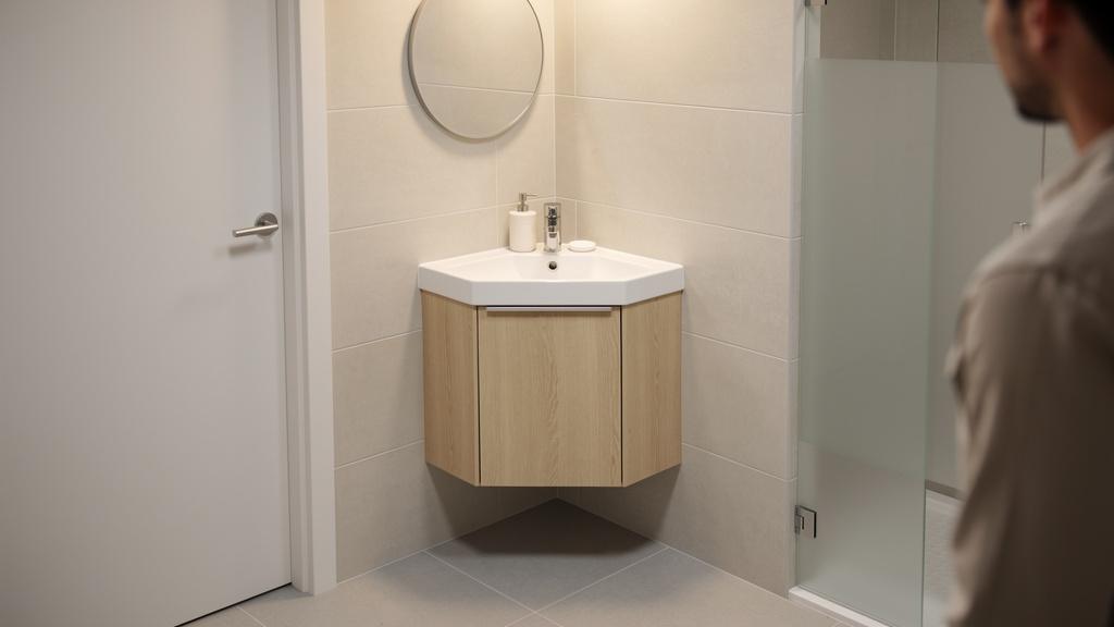 Pose d'un meuble lave-main d'angle dans une petite salle de bain