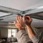 Artisan posant des rails métalliques au plafond