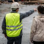 Constructeur examinant des plans sur un chantier de maison individuelle