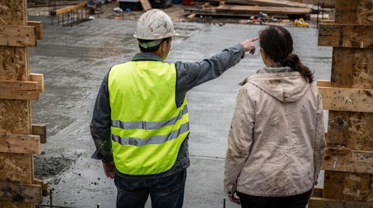 Constructeur examinant des plans sur un chantier de maison individuelle