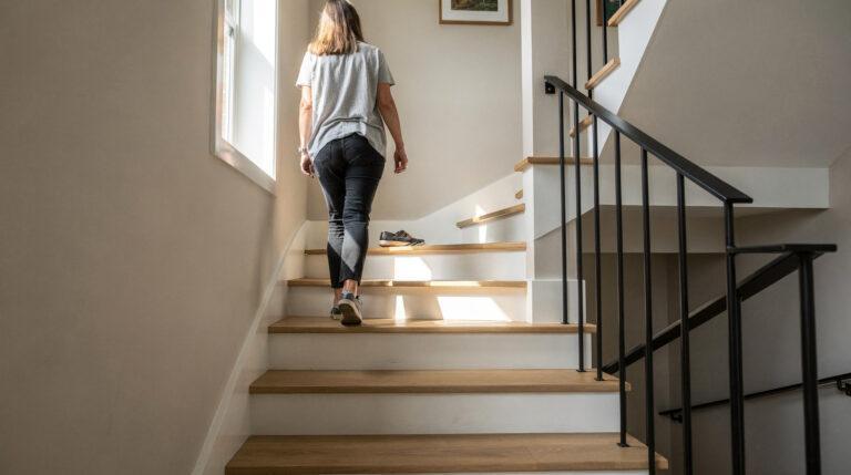 Escalier fermé rénové avec contremarches blanches et rampe moderne