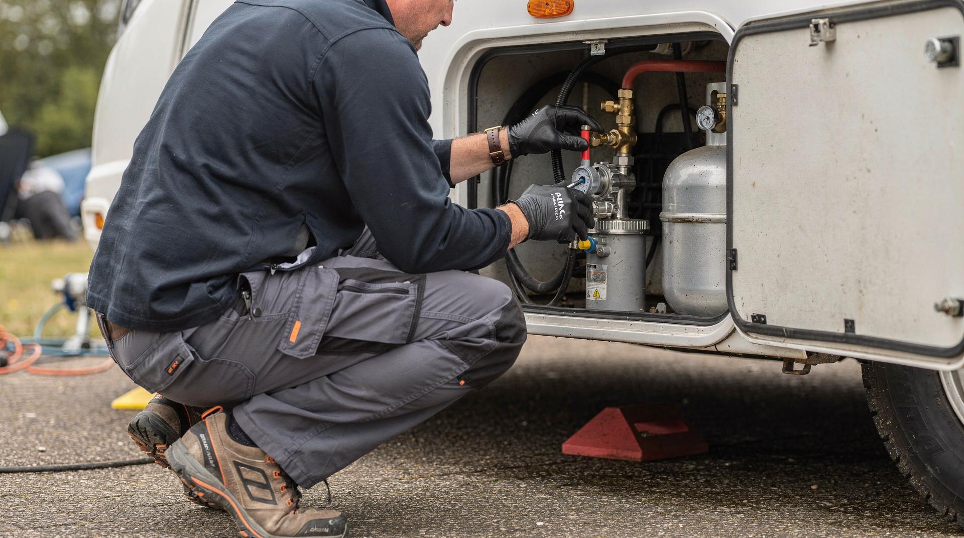 Technicien inspectant le compartiment gaz d'un camping-car